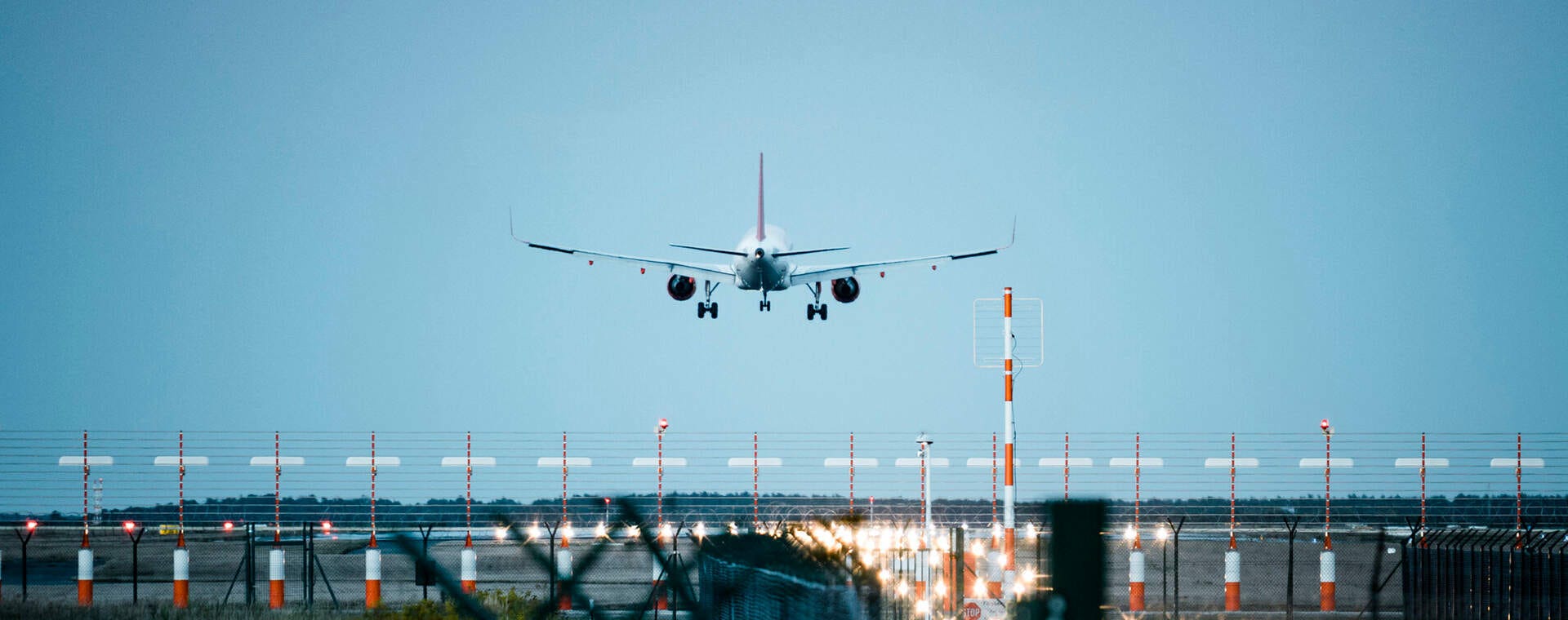 Ein Flugzeug landet sicher auf einer beleuchteten Landebahn. Ein Moment voller Abenteuerlust!